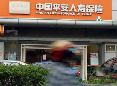 A cyclist rides past shop of Ping An insurance, in Haikou, Hainan province, April 27, 2012. REUTERS/China Daily