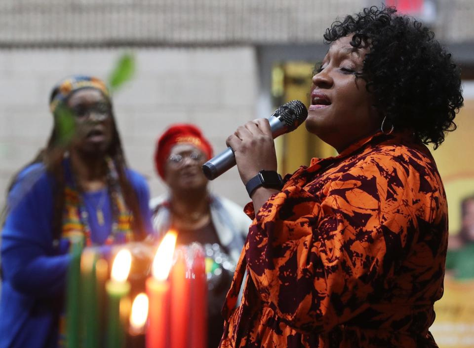 Mary Anderson sings the Black national anthem, "Lift Every Voice and Sing," during the celebration of Ujima, the principle celebrated on the third day of Kwanzaa signifying collective work and responsibility, at the Gus Johnson Community Center in Akron on Thursday. Kwanzaa is seven-day celebration of African-American culture from Dec. 26 to Jan. 1.