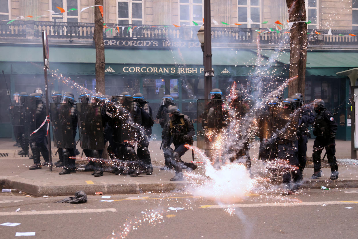 La police anti-émeute française se tient en position alors que des feux d'artifice se déclenchent au milieu d'affrontements avec des manifestants, à Paris le 23 mars 2023. (crédit : REUTERS/Nacho Doce)