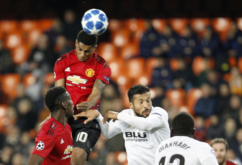 Manchester United's Marcus Rashford, second left, jumps for the ball with Valencia defender Ezequiel Garay, third left, during a Group H Champions League soccer match between Valencia and Manchester United at the Mestalla Stadium in Valencia, Spain, Wednesday, Dec. 12, 2018. (AP Photo/Alberto Saiz)