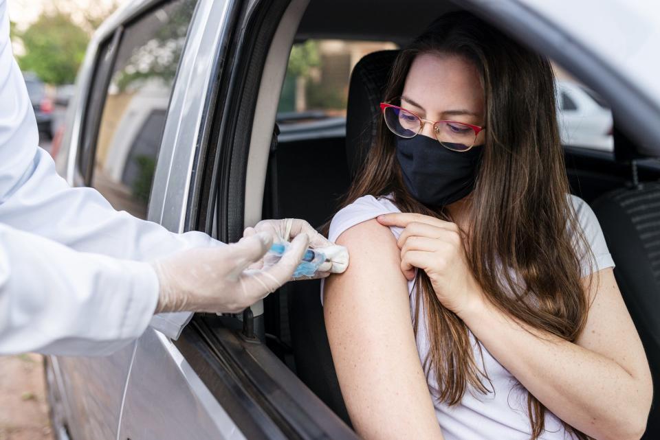 Nurse performing drive-thru immunization.