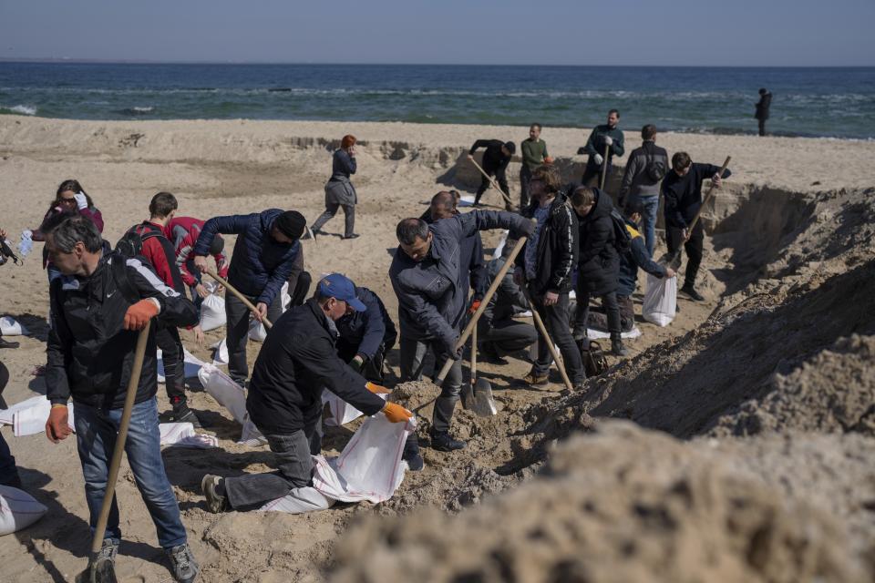 FILE - Volunteers at a beach fill sandbags to defend their city, in Odesa, southern Ukraine, on March 23, 2022. The Black Sea port is mining its beaches and rushing to defend itself from a Mariupol-style fate. (AP Photo/Petros Giannakouris, File)