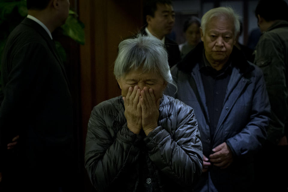 An elderly woman, one of the relatives of Chinese passengers aboard missing Malaysia Airlines Flight MH370, covers her face out of frustration as she leaves a hotel ballroom after a daily briefing meeting with managers of Malaysia Airlines in Beijing, China, Wednesday, March 19, 2014. Search crews from 26 countries are looking for Malaysia Airlines Flight 370, which vanished early March 8 with 239 people aboard en route from Kuala Lumpur to Beijing. Frustration is growing among relatives of those on the plane at the lack of progress in the search. (AP Photo/Alexander F. Yuan)