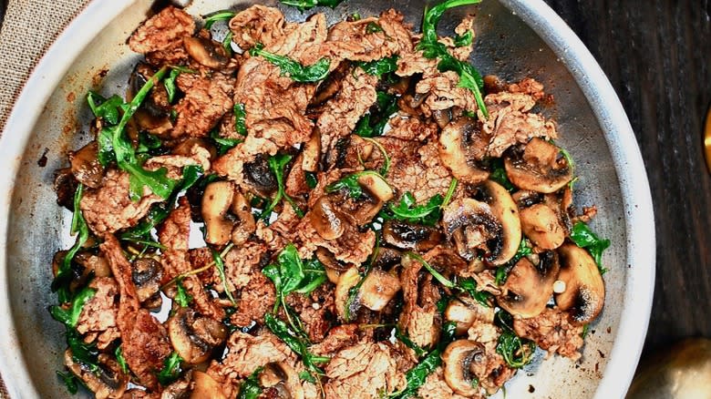 shaved beef and vegetable stir fry in skillet