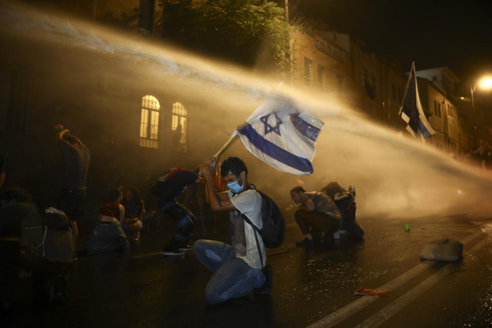 Israeli police uses water canon to disperse people during a protest against Israeli Prime Minister Benjamin Netanyahu In Jerusalem Saturday, July 18, 2020. Protesters demanded that the embattled Israeli leader to resign as he faces a trial on corruption charges and grapples with a deepening coronavirus crisis.(AP Photo/Oded Balilty)