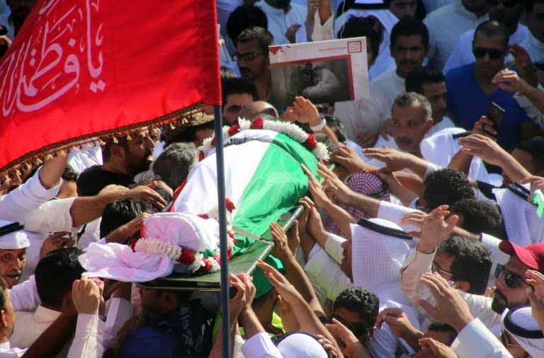 Mourners carry the body of one of the victims of the Al-Imam Al-Sadeq mosque bombing, during a mass funeral at Jaafari cemetery in Kuwait City on June 27, 2015