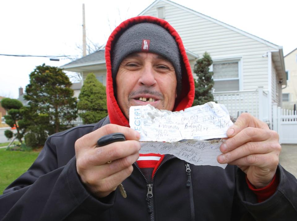 A tenant from the house holds up the receipt he received from Brian Rodriguez who claims to be working on getting the tenants out so the home’s owner can take control of it. James Messerschmidt