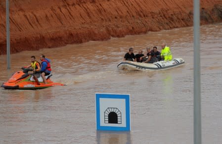 Rescue workers on a boat rescue a person who was stranded inside a flooded tunnel after heavy floods in Pilar de la Horadada