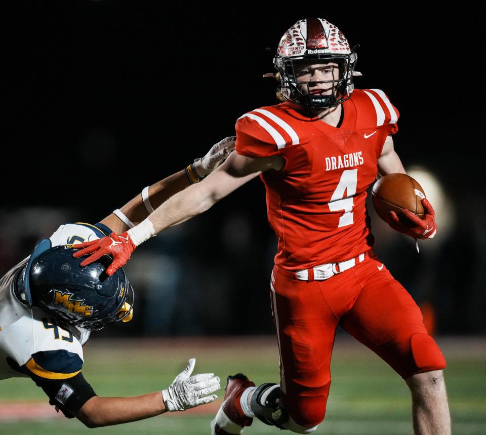 New Palestine Dragons Grayson Thomas (4) stiff-arms Mooresville Pioneers Trey Bennett (45) during the IHSAA Class 4A Regional Championship game between Mooresville Pioneers and New Palestine Dragons Friday, Nov. 10, 2023, at New Palestine High School in New Palestine. Dragons defeated Pioneers 39-6.