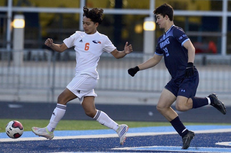 Bartlesville High's Austin Bastings, right, closes in on an Heritage (Ark.) player during soccer action on March 28, 2023, in Bartlesville.