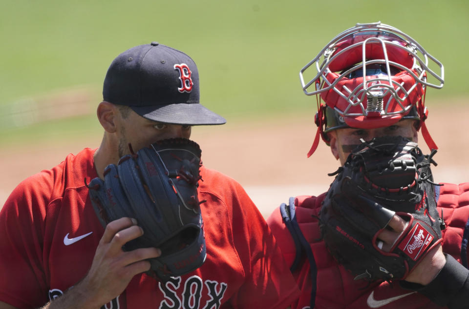 Boston Red Sox starting pitcher Nathan Eovaldi, left, talks with catcher Christian Vazquez as they walk off the field at the end of the second inning of a spring training baseball game against the Tampa Bay Rays, Friday, March 19, 2021, in Fort Myers, Fla.. (AP Photo/John Bazemore)