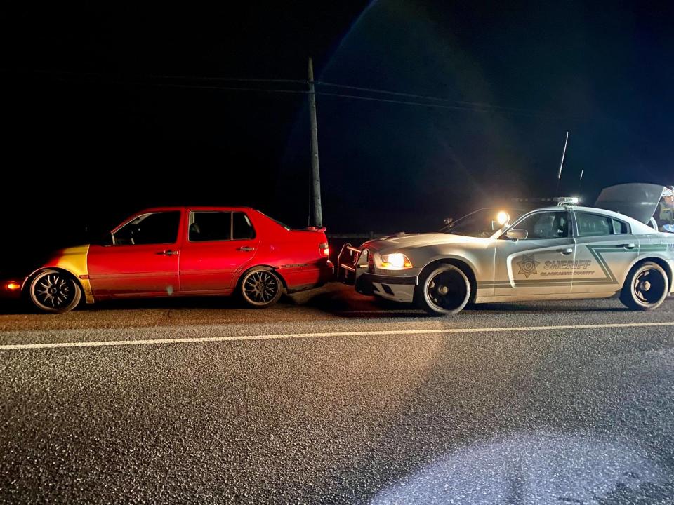 A Volkswagen Jetta is seen next to a police car.