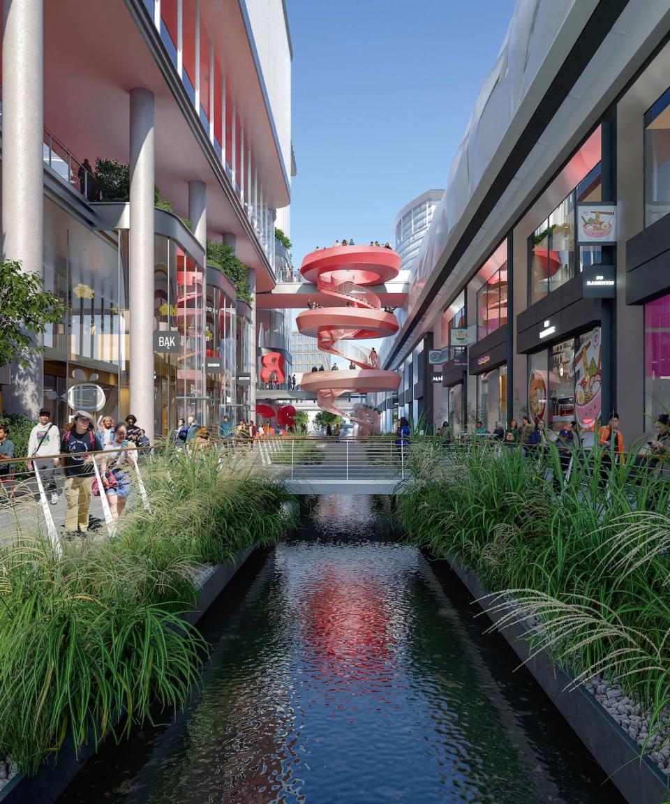 A mockup of the planned redevelopment project for HSBC's London HQ in Canary Wharf. A red spiral staircase leads down from a walkway to a commercial area with a water feature running through the middle.