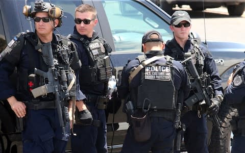 U.S. Customs and Border Protection officers gather near the scene of a shooting at a shopping mall in El Paso - Credit: AP