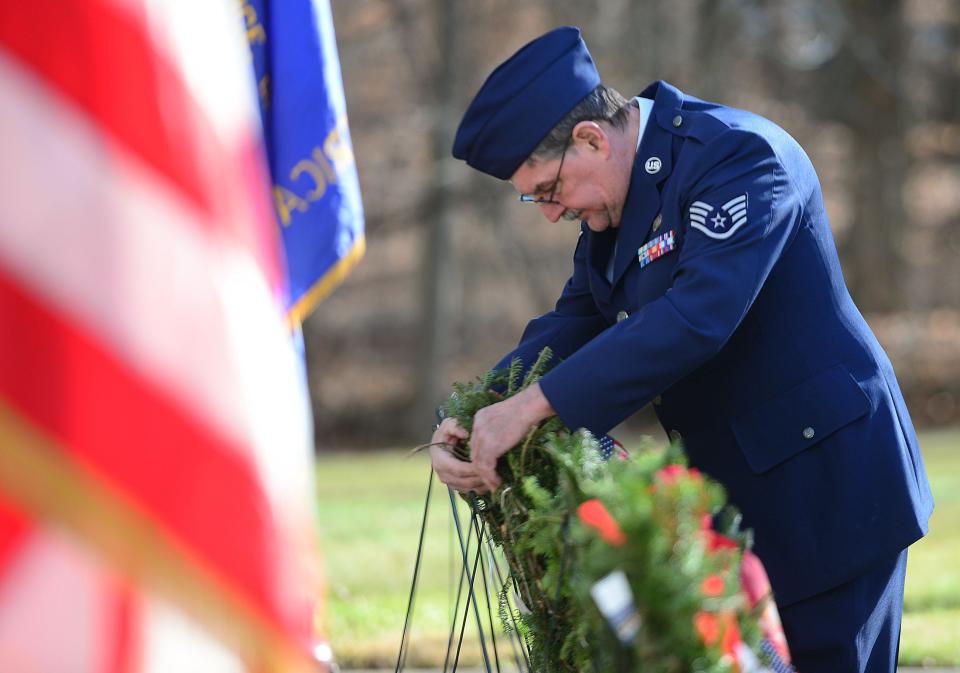 Air Force Staff Sgt. William Brown places a ceremonial wreath at the Veterans Memorial at Alliance City Cemetery during the Wreaths Across America ceremony on Saturday, Dec. 16, 2023.