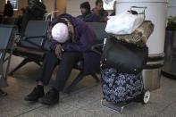 A woman sleeps at LaGuardia airport on the day before Thanksgiving in New York November 26, 2014. REUTERS/Carlo Allegri