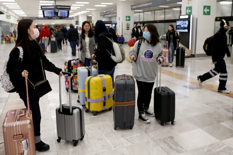 FOTO DE ARCHIVO: Turistas con máscaras protectoras llegan en un vuelo de Hainan Airlines desde Pekín al aeropuerto internacional Benito Juárez en Ciudad de México.