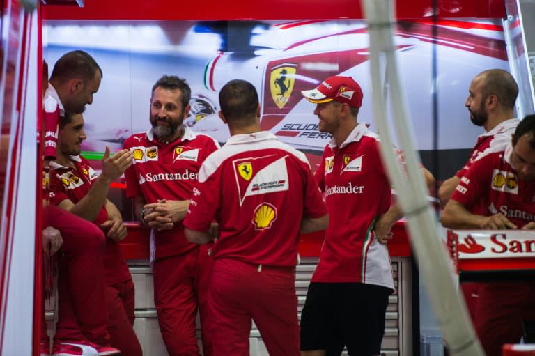 German driver Sebastian Vettel (centre R) of Ferrari arrives at the paddock ahead of the Singapore Grand Prix on September 15, 2016