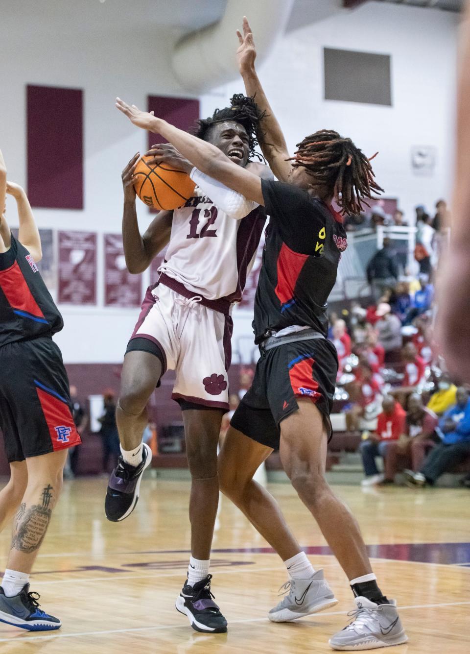 Omarayon Turner (1) tries to stop James Robinson (12) as he drives to the hoop during the Pine Forest vs PHS boys basketball game at Pensacola High School on Friday, Jan. 14, 2022.