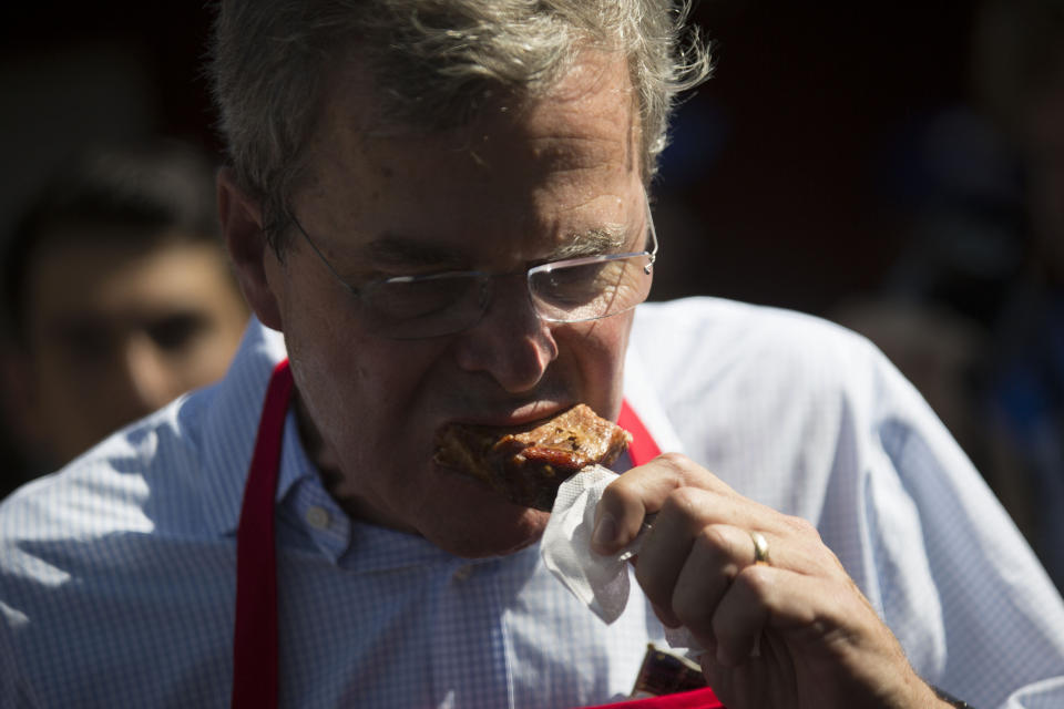<p>Jeb Bush eats a pork chop on a stick at the Iowa Pork Producers Association stand.</p>