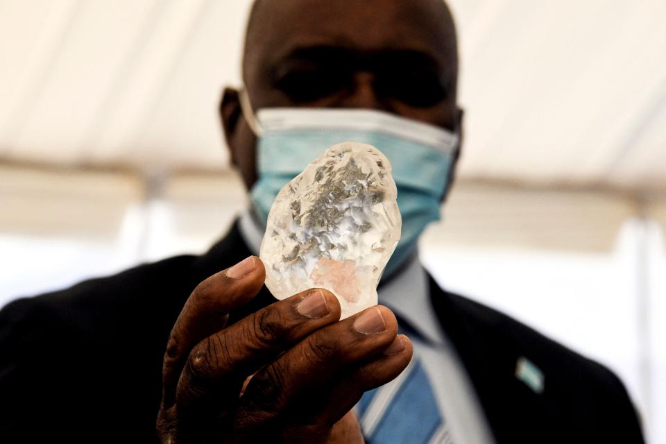 Botswana President Mokgweetsi Masisi holds a gem diamond (Photo by MONIRUL BHUIYAN/AFP via Getty Images)