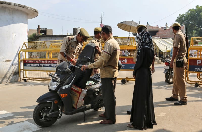 Policemen check a scooter at a security barricade on the road leading to a disputed religious site where Hindu religious groups are demanding the construction of a temple in Ayodhya