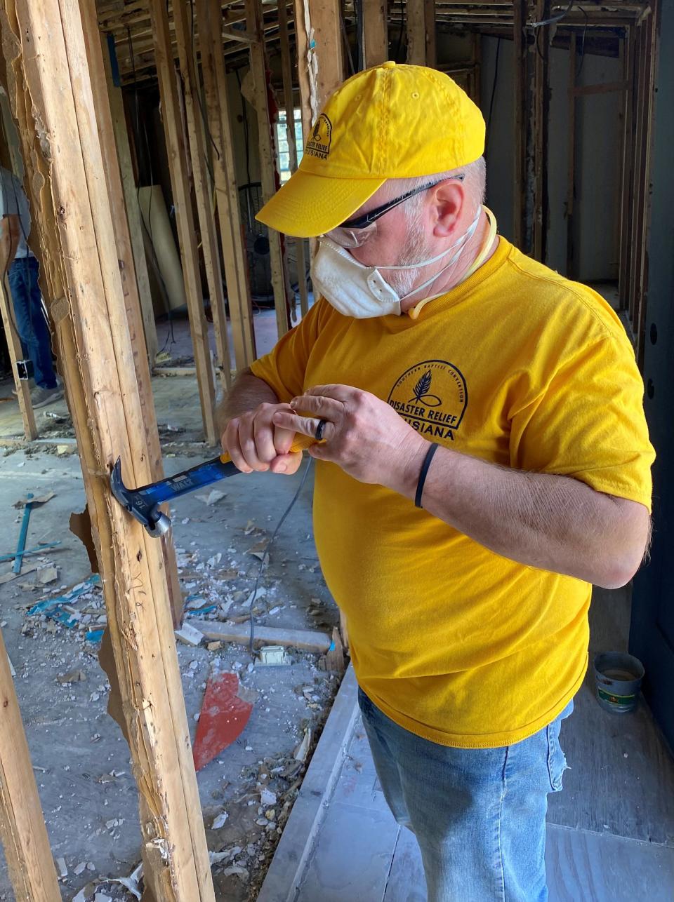 A worker from Disaster Relief Louisiana works on the frame of a wall with tools provided by the New Orleans Toolbank.