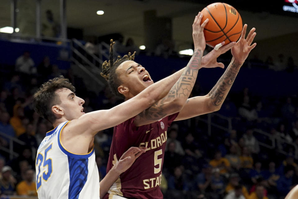 Pittsburgh's Guillermo Diaz Graham (25) reaches for a rebound against Florida State's De'Ante Green (5) during the first half of an NCAA college basketball game Tuesday, March 5, 2024, in Pittsburgh. (AP Photo/Matt Freed)