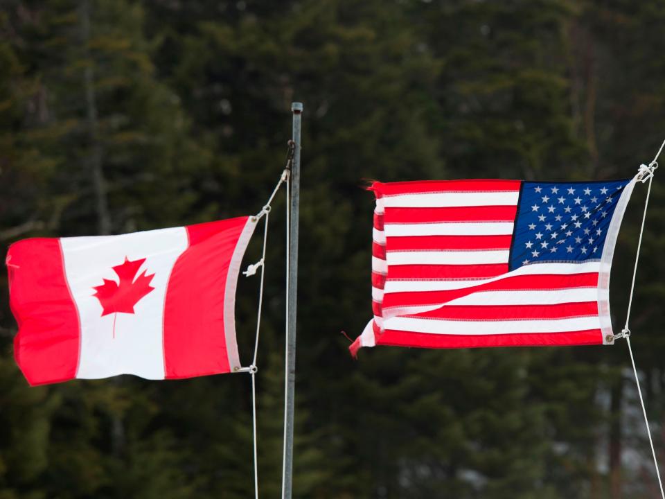 <p>Banderas canadienses y estadounidenses se ven en la frontera entre Estados Unidos y Canadá el 1 de marzo de 2017, en Pittsburg, New Hampshire. </p> (Foto de Don EMMERT AFP a través de Getty )