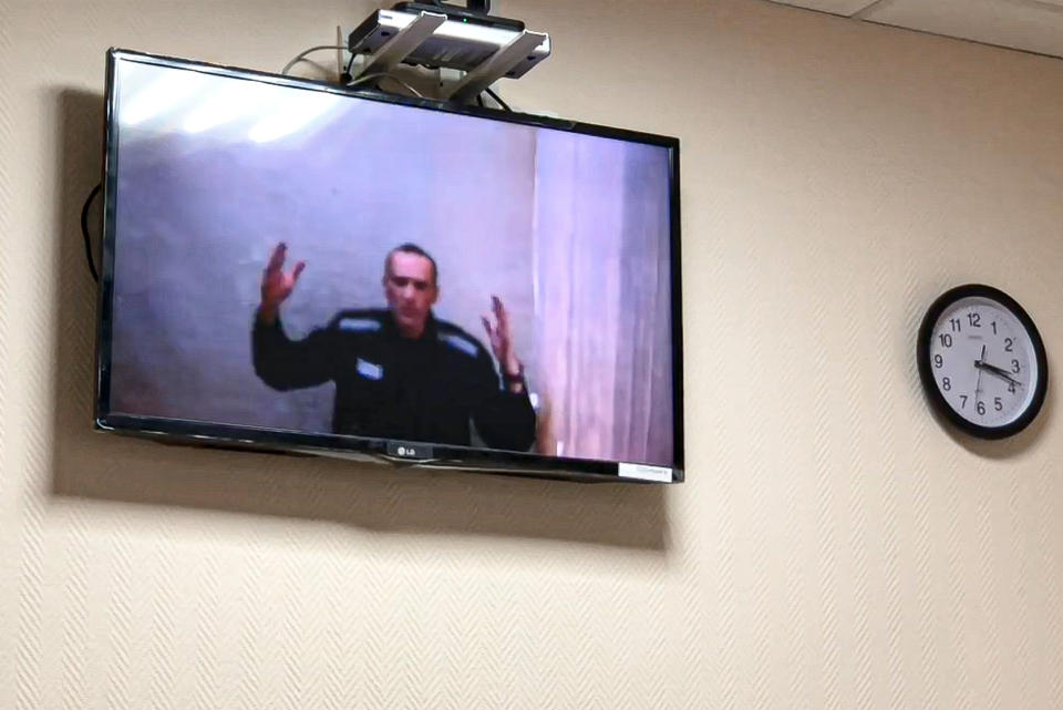 Russian opposition leader Alexei Navalny gestures speaking in a video link from a prison during a court session in Petushki, Vladimir region, about 120 kilometers (75 miles) east of Moscow, Russia, Monday, May 31, 2021. Imprisoned Russian opposition leader Alexei Navalny has asked a court to halt the hourly nighttime checks he has been subjected to in his penal colony. Speaking Monday in a video link from prison, Navalny charged that he has done nothing that would warrant the authorities' decision to designate him as a flight risk that has resulted in checks. (TV Rain via AP)