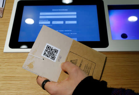 A staff member holds the customer card to order the knitting pattern at the Adidas Knit for You store in Berlin, Germany March 7, 2017. Picture taken March 7, 2017. REUTERS/Fabrizio Bensch