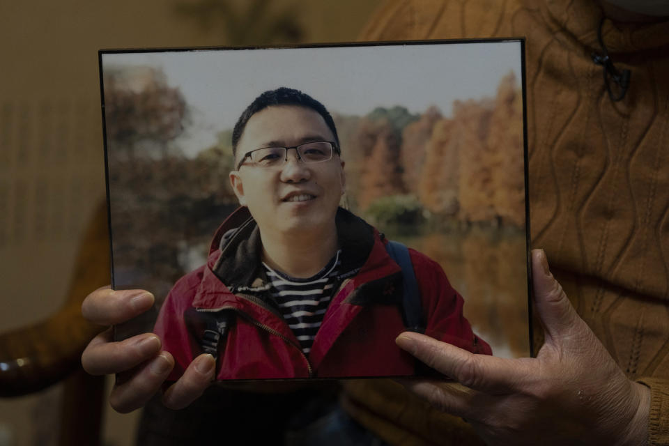 Zhong Hanneng holds a photo of her son, Peng Yi, and talks about his difficulties in getting tested for COVID-19, eventually dying from the disease, in Wuhan in central China's Hubei province on Saturday, Oct. 17, 2020. Widespread test shortages and problems at a time when the coronavirus arguably could have been curbed were caused largely by secrecy and cronyism at China’s top disease control agency, an Associated Press investigation has found. (AP Photo/Ng Han Guan)