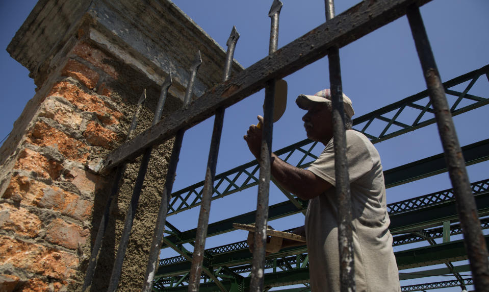 El trabajador Néstor Rosales repara un portón en la estación central de La Habana, Cuba, 22 de mayo de 2019. El sistema ferroviario cubano está en proceso de reconstrucción y modernización para restaurar un servicio que fue la envidia de Latinoamérica. (AP Foto/Ismael Francisco)