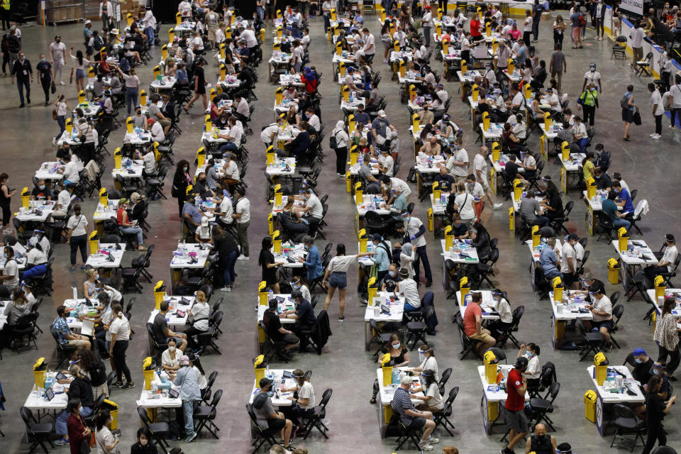 FILE - In this Sunday, June 27, 2021 file photo, people receive a dose of the COVID-19 vaccine at a mass vaccination clinic at Scotiabank Arena in Toronto. (Cole Burston/The Canadian Press via AP)