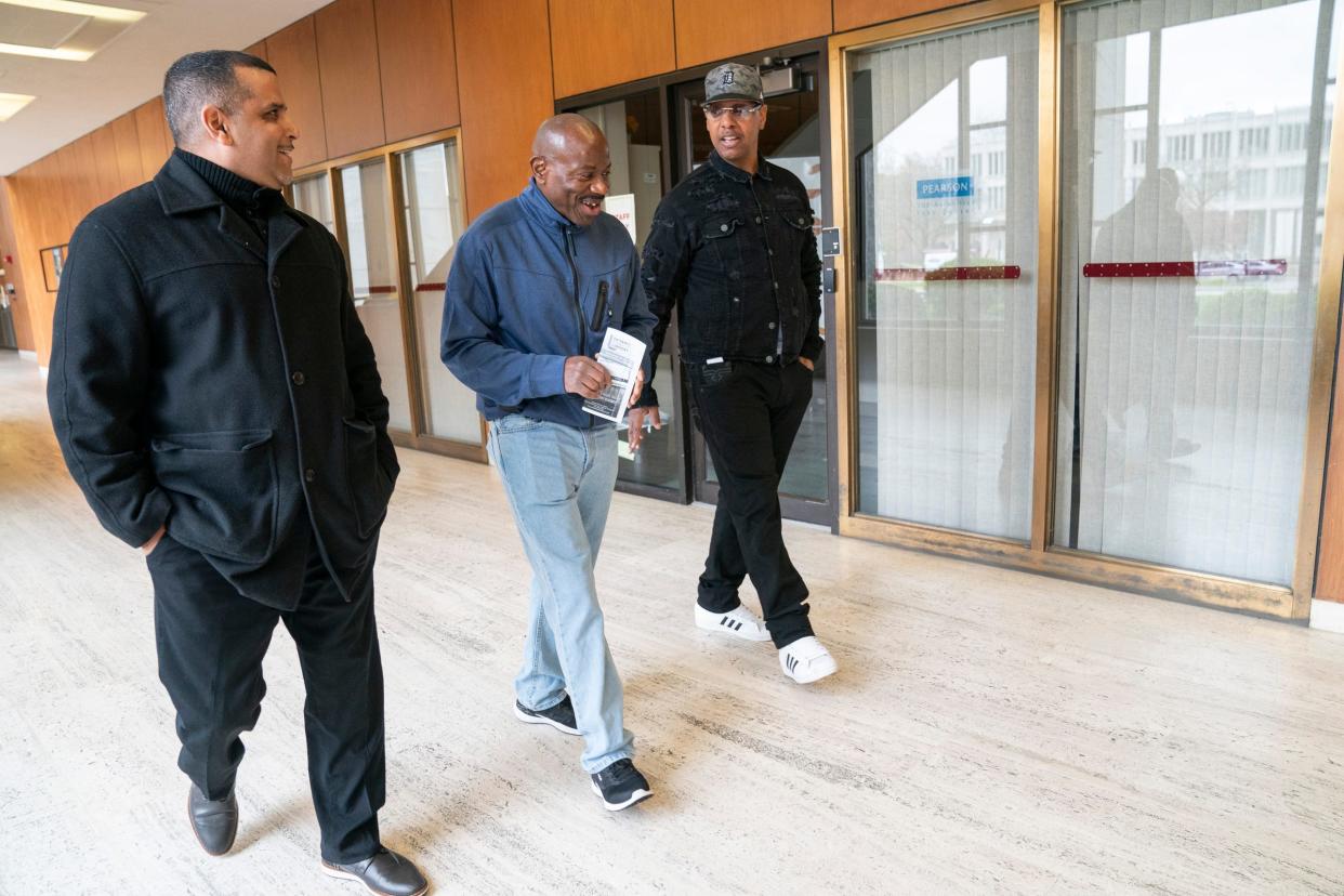 Jose Burgos, 48, of Ecorse, left, walks through the Detroit Public Library with Albert Garrett, 60, recently released from prison after 44 years,  and Ronnie Waters, 60, of West Bloomfield, on Monday, May 1, 2023. Both Burgos and Waters are part of an advocacy effort to end the practice of sentencing juveniles to life in prison without parole in Michigan.