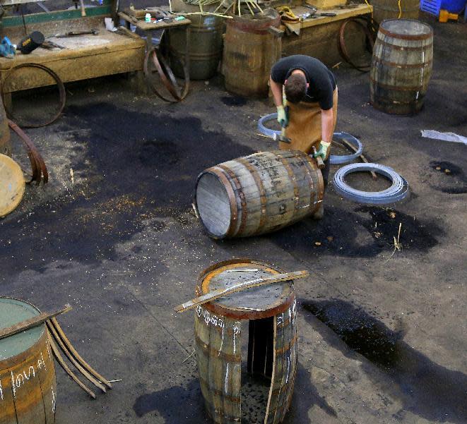 In this photo taken June 28, 2016, a worker at the cooperage of the Balvenie distillery in Dufftown, in the Speyside region of Scotland, works on a whisky barrel. The distillery also has a working malting floor and offers tours and tastings. (Michelle Locke via AP)