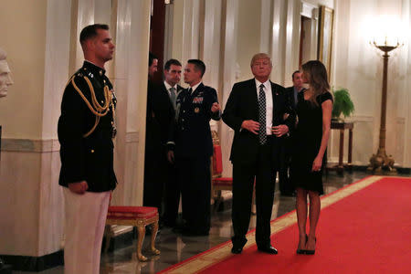 U.S. President Donald Trump and First Lady Melania Trump arrive to host a reception for Senators and their spouses at the East Room of the White House in Washington, U.S., March 28, 2017. REUTERS/Carlos Barria