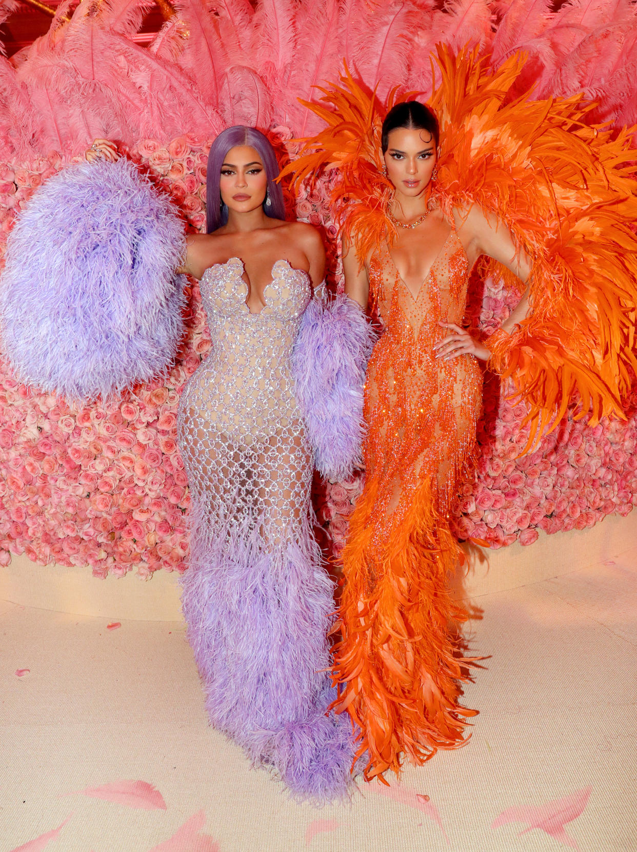 A photo of Kylie Jenner wearing a purple dress and Kendall Jenner wearing an orange dress at the 2019 Met Gala Celebrating Camp: Notes on Fashion at Metropolitan Museum of Art on May 06, 2019 in New York City.