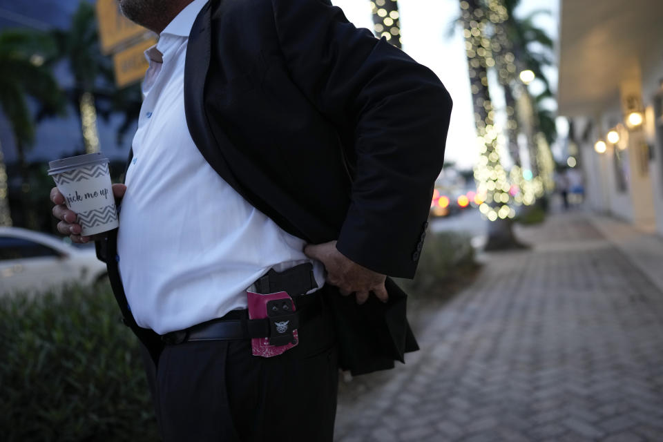 A Jewish man shows off the small gun he carries for protection, as he arrives at a synagogue for Shabbat service, in Miami Beach, Fla., Friday, Dec. 1, 2023. Rabbis say many families are asking if it’s permissible to buy guns for protection, worried by antisemitic rhetoric and attacks globally as Israel faces intensifying criticism for the mounting Palestinian casualty toll. (AP Photo/Rebecca Blackwell)