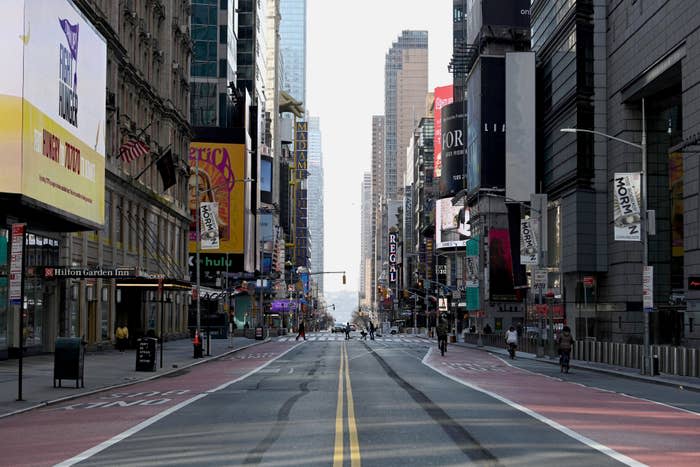 An empty urban street with storefronts and billboards, suggesting a desolate city atmosphere