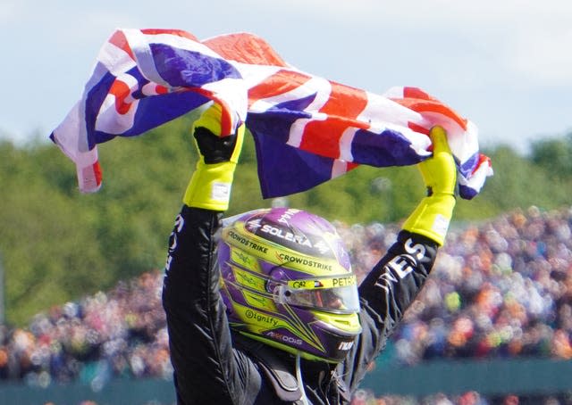 Lewis Hamilton holds a Union flag above his head after winning the British Grand Prix