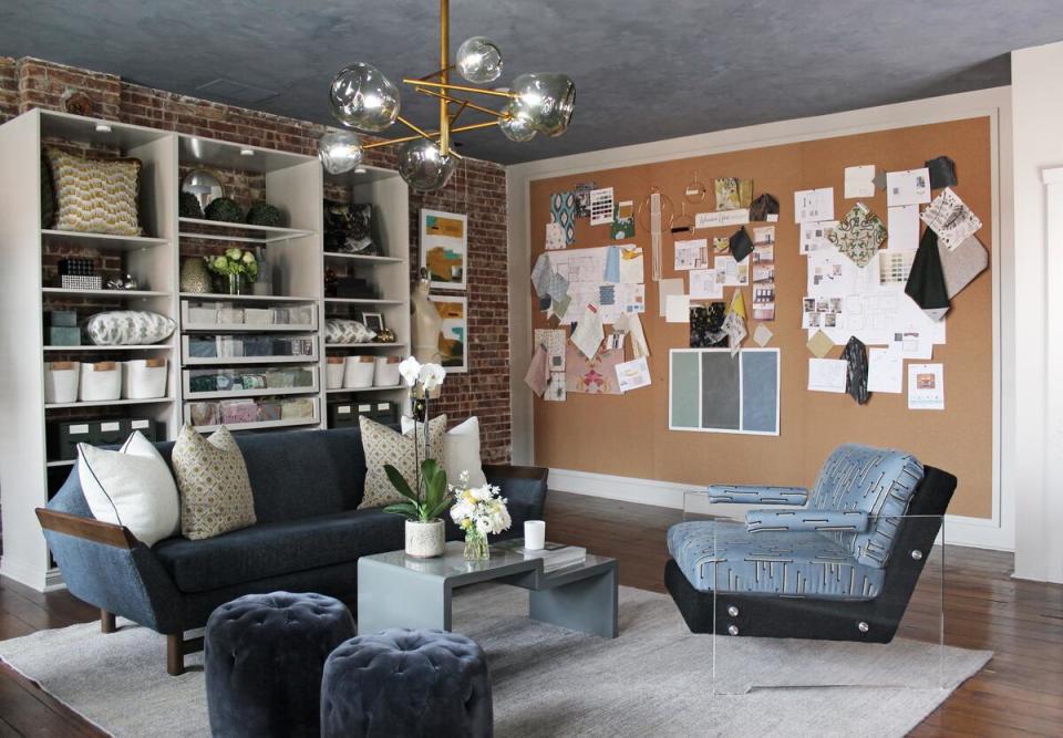 A pinboard with project inspiration is the backdrop for a sleek, stylish seating arrangement in Lyon’s studio