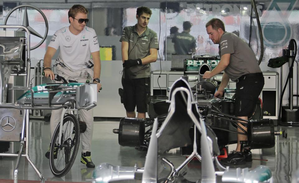 Mercedes Formula One driver Nico Rosberg of Germany heads out with a bicycle from his team garage at the Buddh International Circuit in Greater Noida on the outskirts of New Delhi October 24, 2013. The Indian F1 Grand Prix will take place from October 25-27. REUTERS/Anindito Mukherjee (INDIA - Tags: SPORT MOTORSPORT F1)