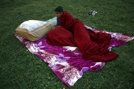 A boy lies down in an open ground to keep safe after an earthquake in Kathmandu, Nepal April 26, 2015. REUTERS/Navesh Chitrakar