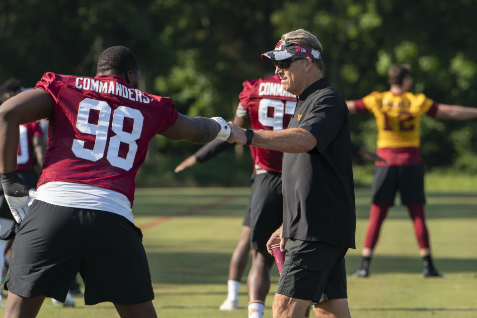 Washington Commanders NFL football team defensive coordinator Jack Del Rio, gives defensive tackle Phidarian Mathis (98) a fist bump during the team's NFL football practice in Ashburn, Va., Wednesday, June 1, 2022. (AP Photo/Manuel Balce Ceneta)