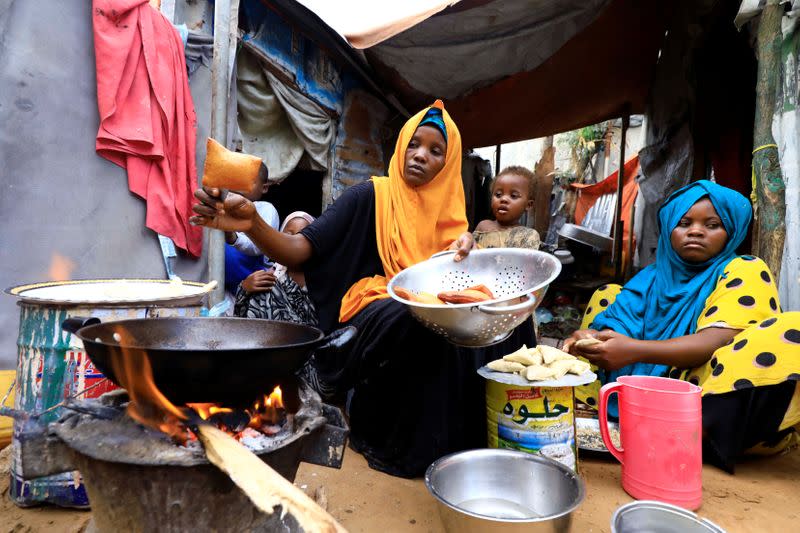 An internally displaced Somali woman and her children prepare their Iftar meal during the month of Ramadan at the Shabelle makeshift camp in Hodan district of Mogadishu