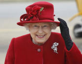 FILE - Britain's Queen Elizabeth II holds on to her hat in high winds as she arrives for a visit to RAF Valley, Anglesey, Wales on April 1, 2011. (AP Photo/Christopher Furlong, File)