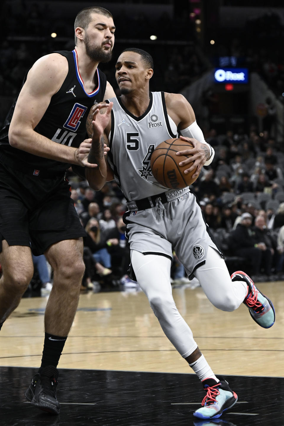 San Antonio Spurs' Dejounte Murray (5) drives against Los Angeles Clippers' Ivica Zubac during the first half of an NBA basketball game, Saturday, Jan. 15, 2022, in San Antonio. (AP Photo/Darren Abate)