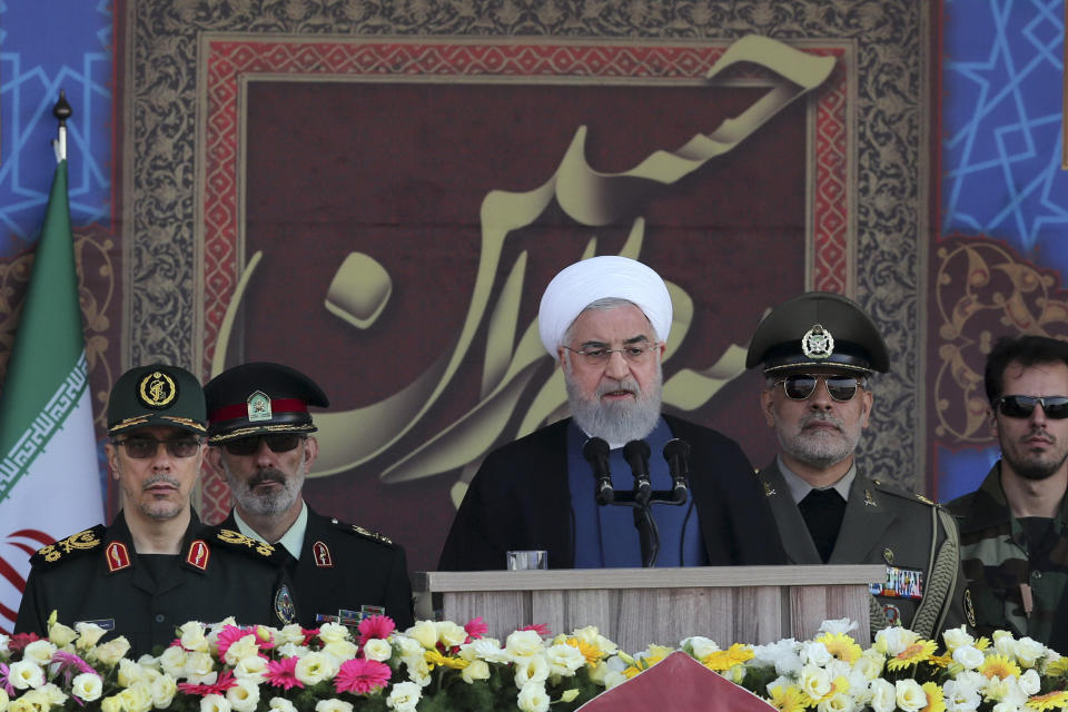 In this photo released by the official website of the office of the Iranian Presidency, President Hassan Rouhani speaks at a military parade marking 39th anniversary of outset of Iran-Iraq war, in front of the shrine of the late revolutionary founder Ayatollah Khomeini, just outside Tehran, Iran, Sunday, Sept. 22, 2019. Chief of the General Staff of the Armed Forces Gen. Mohammad Hossein Bagheri stands at left. (Iranian Presidency Office via AP)