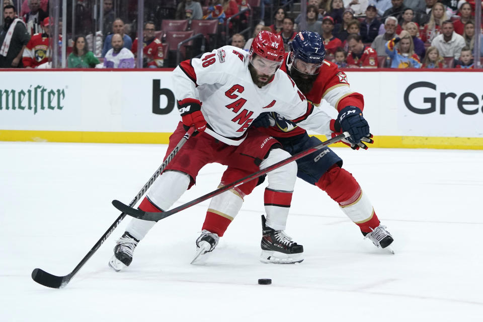 Carolina Hurricanes left wing Jordan Martinook (48) battles for the puck with Florida Panthers defenseman Radko Gudas (7) during the first period of Game 4 of the NHL hockey Stanley Cup Eastern Conference finals, Wednesday, May 24, 2023, in Sunrise, Fla. (AP Photo/Wilfredo Lee)